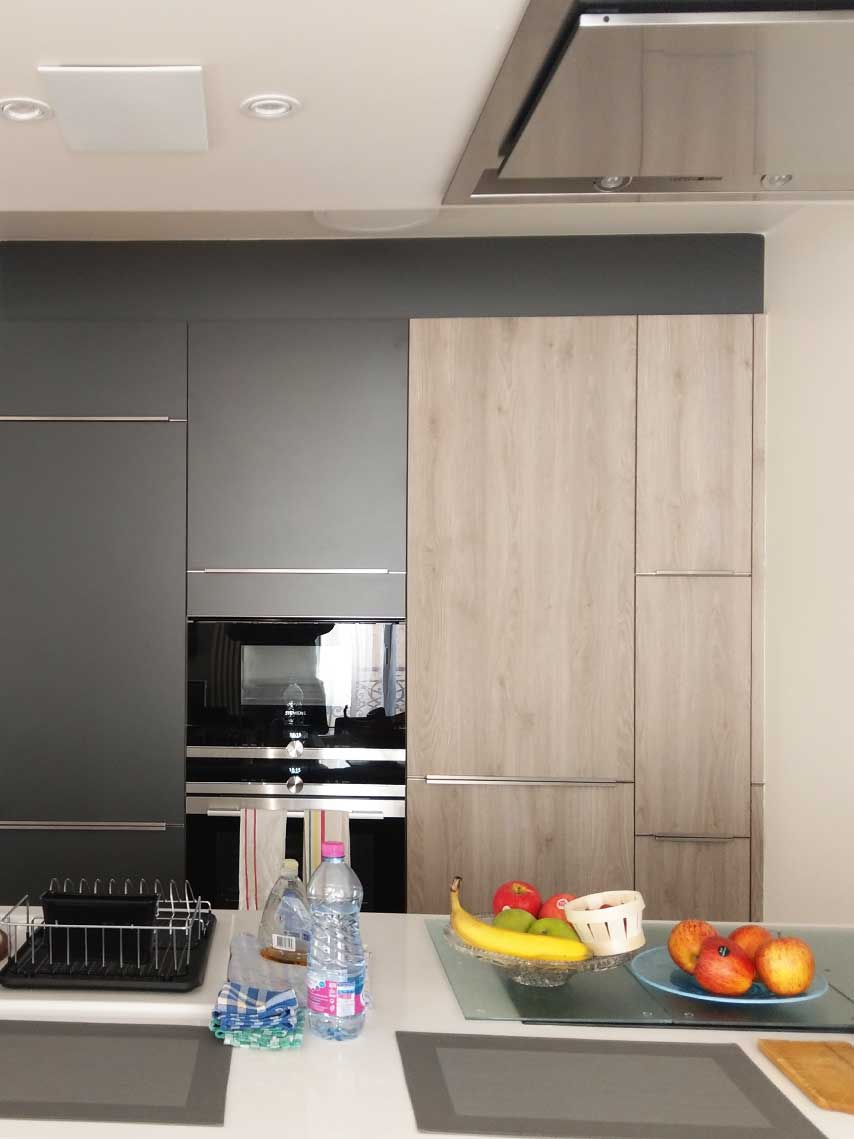 Cuisine rénovée avec meubles gris et colonnes en chêne — Paris