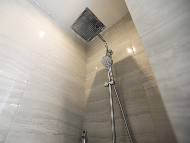 Douche à l'italienne ciel de pluie en pierre beige — rénovation Paris