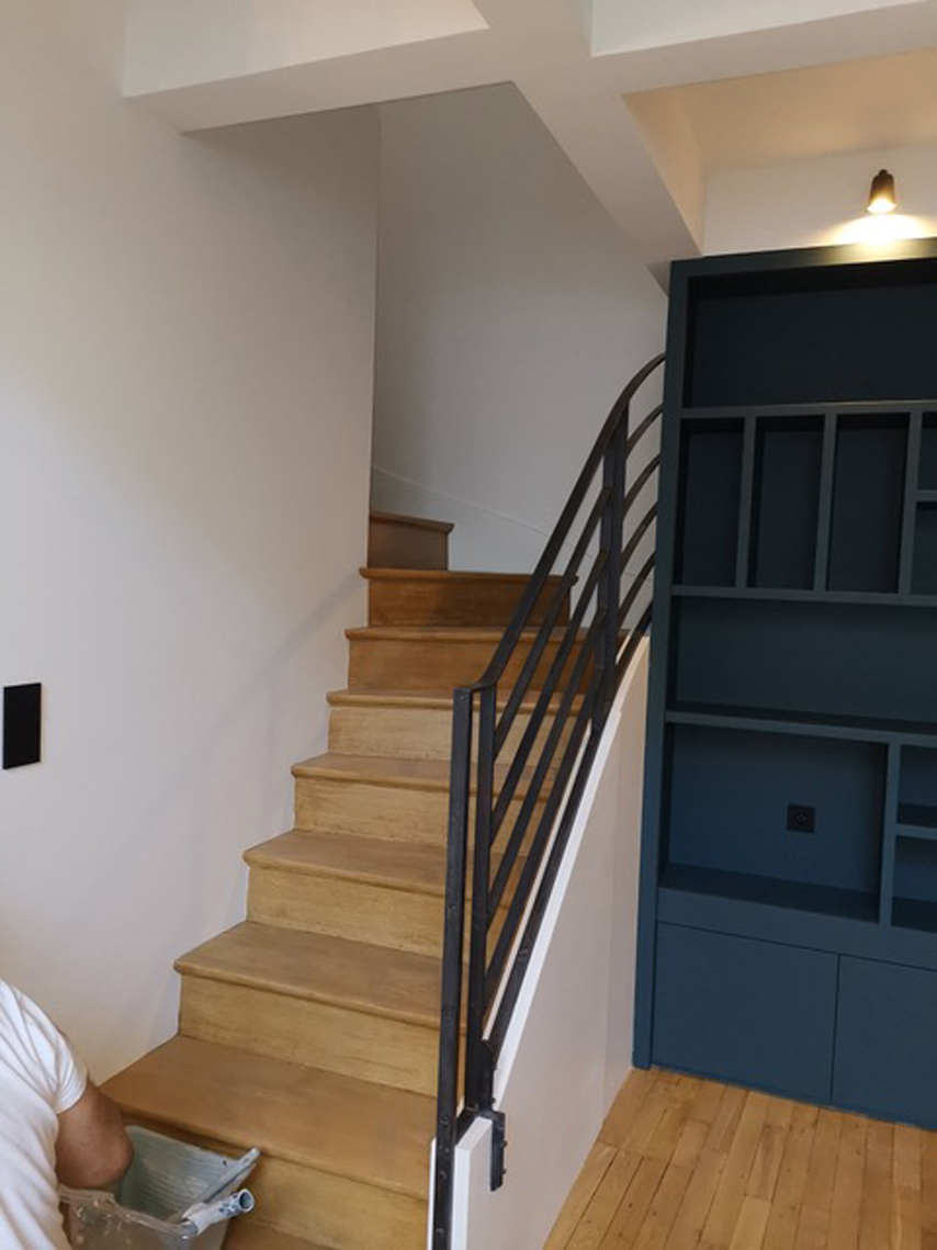 Escalier avec bibliothèque bleu navy en cours de chantier — rénovation Paris